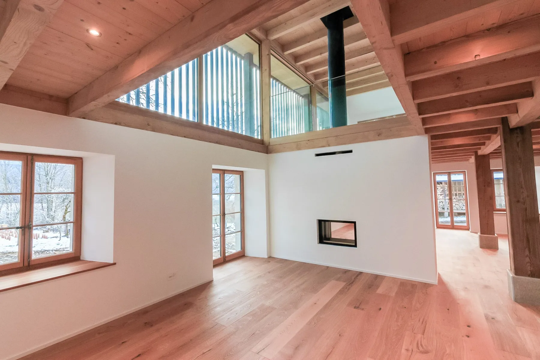Intérieur d'une ferme rénovée, charpente et fenêtres en bois
