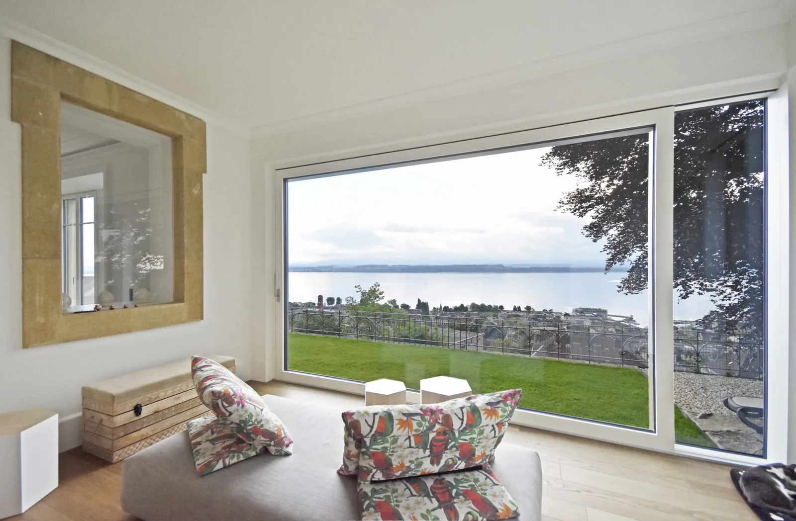 Grande baie vitrée d'une maison de maître, vue sur le lac